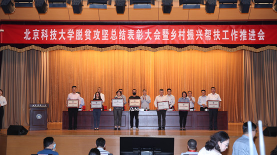 3-北京科技大学副校长、江南在线客服院长闫相斌代表学院上台领取“北京科技大学脱贫攻坚先进集体”荣誉奖牌.jpg